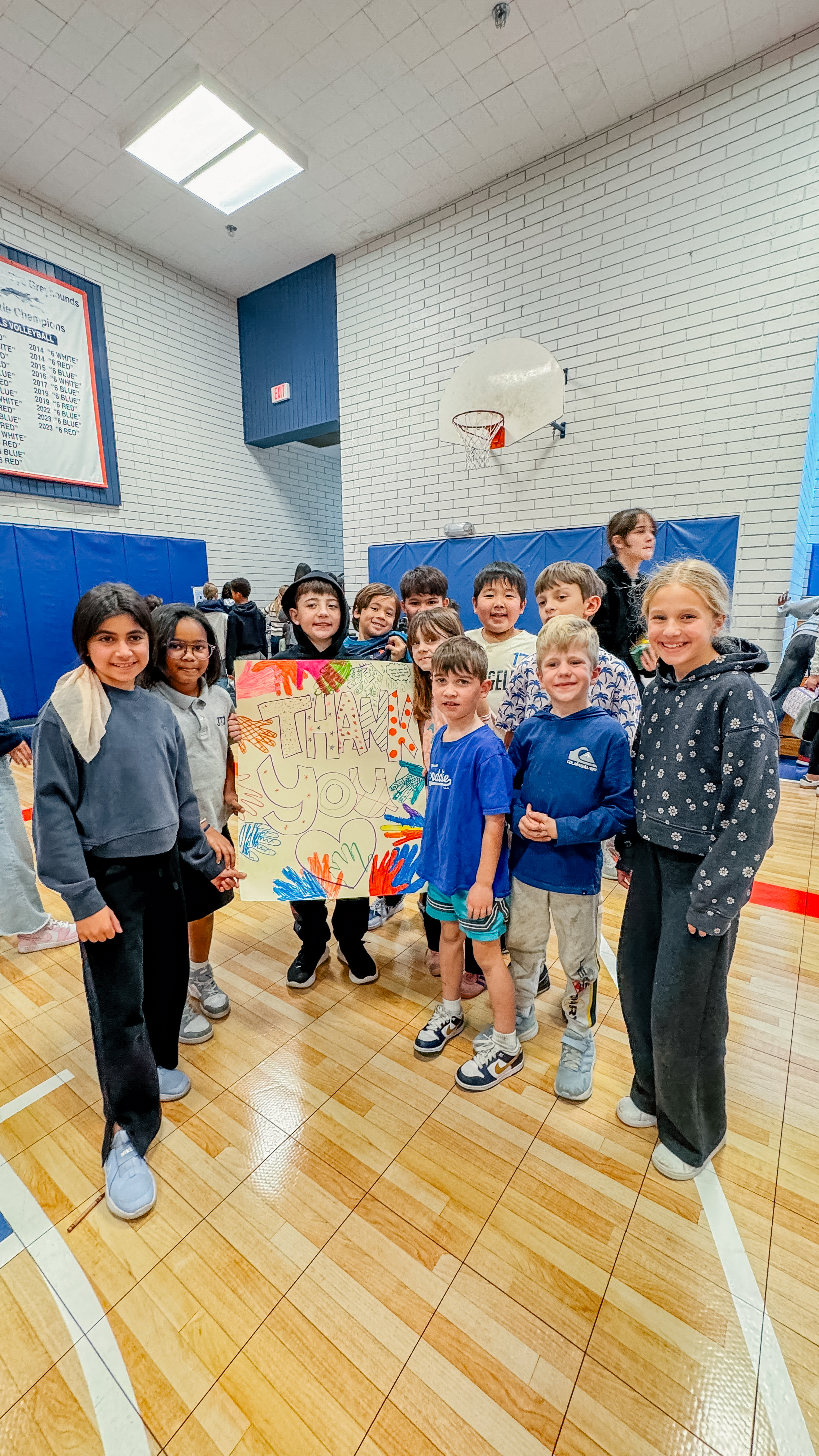 A JTD Family group poses around a Banner, thanking first responders.
