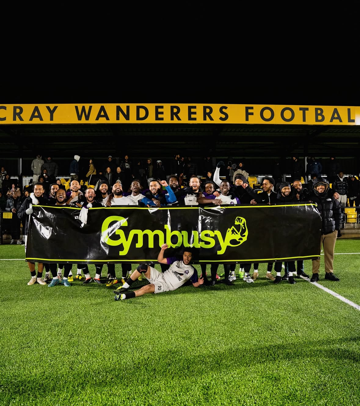 long banner being held on football pitch in group photo