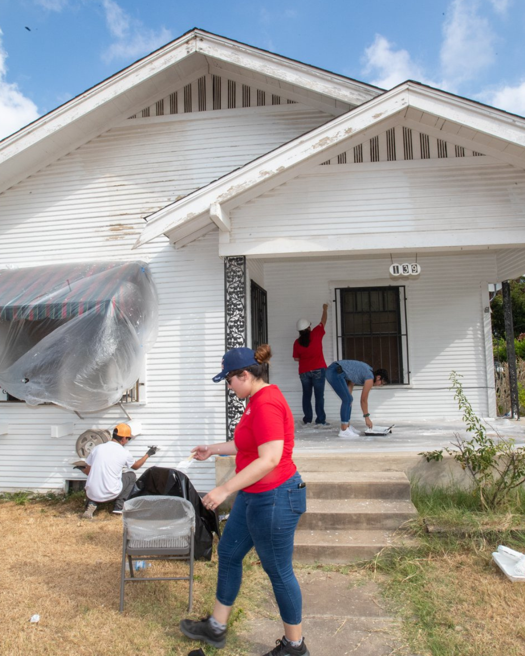 white craftsman house being painted by people
